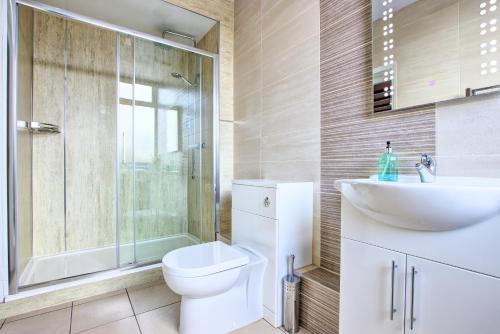 奥特本Butterchurn Guest House的浴室配有卫生间、盥洗盆和淋浴。