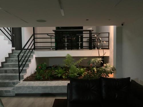 马尼萨莱斯Apartahotel La Arboleda HC的客厅设有植物楼梯