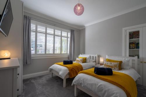 爱丁堡Craigey Beach Home的一间卧室设有两张床和窗户。