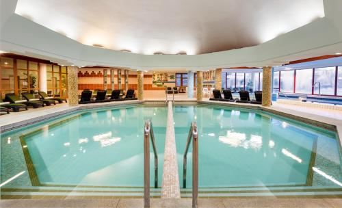 陶波尔曹皮利恩宏格斯特酒店的酒店大堂的游泳池,配有椅子