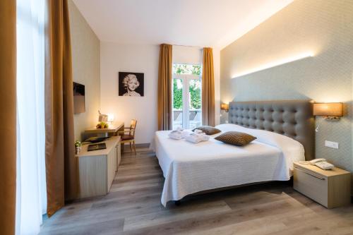 蒙特格罗托泰梅米欧尼罗依尔胜酒店的配有一张床、一张书桌和一扇窗户的酒店客房