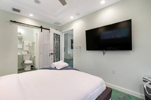 好莱坞Heated Pool I Soundproof Home I Firepit I 630Mbps的卧室配有一张白色大床和一台平面电视。