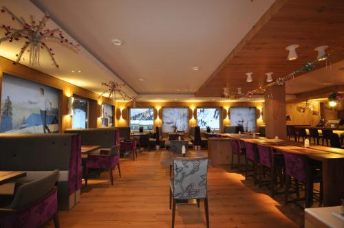 上陶恩克里斯特酒店的餐厅铺有木地板,配有桌椅