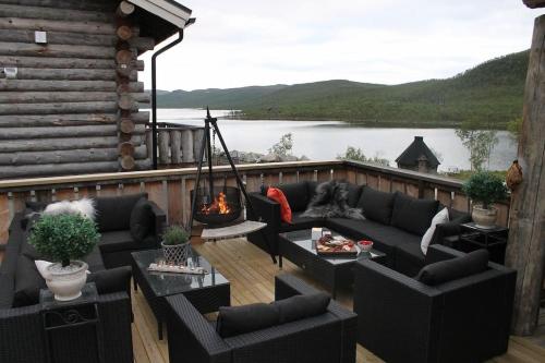 基尔匹斯扎我维Kelo Aurora luxury cabin的一个带沙发和椅子的甲板和一个火坑