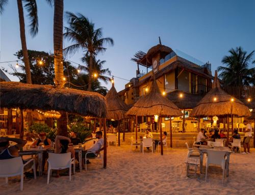 普拉亚卡门考利布里海滩酒店的一群人坐在度假村前的桌子上