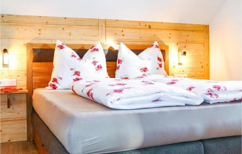 WeisspriachCozy Home In Weisspriach With Sauna的一张带白色床单和红色及白色枕头的床