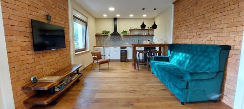 多博沃Olivea的一间带蓝色沙发的客厅和一间厨房