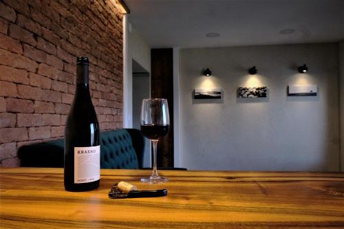 多博沃Olivea的一瓶葡萄酒和一张木桌上的玻璃杯
