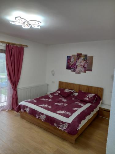 Casa Daria的一间卧室配有一张带紫色床单的床和窗户。
