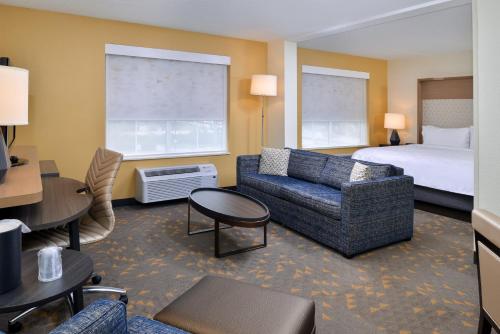 欧弗兰帕克欧弗兰帕克会议中心套房假日酒店的酒店客房配有一张床、一张沙发和椅子。