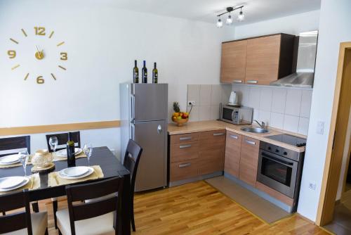 库普雷斯Holiday home Maša - Kupres的厨房配有桌子和不锈钢冰箱。