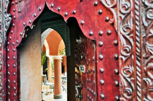 马拉喀什本萨义德摩洛哥传统住宅的红色的门,上面有一大堆珠子