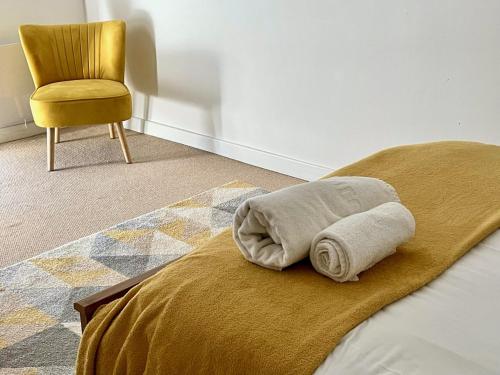 达灵顿Central Darlington Apartment With Parking的一张带毛巾和椅子的床