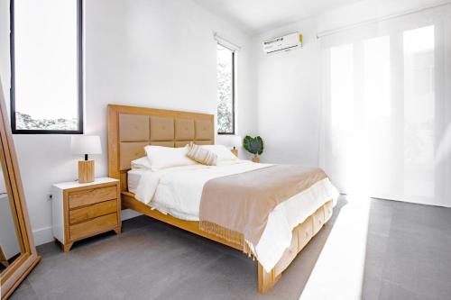 普拉纳维瑙Ocean view luxury Villa, Private Pool 4BD 8PPL的白色卧室设有一张大床和一个床头柜