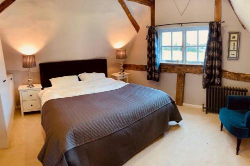 贝德福德2 Beds & living in our idyllic country Cottage的一间卧室设有一张大床和一个窗户。