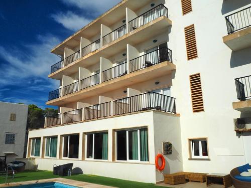 卡拉菲格拉洛卡马尔酒店的带阳台和游泳池的白色建筑
