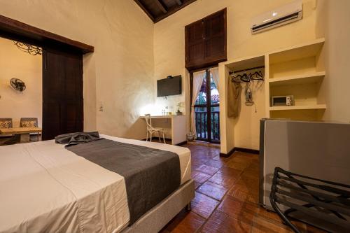 卡塔赫纳Casa BuGo的一间卧室配有一张床和一台电视。