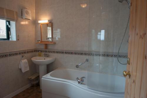 布兰德福德福鲁姆兰顿阿姆斯酒店的带浴缸和盥洗盆的浴室