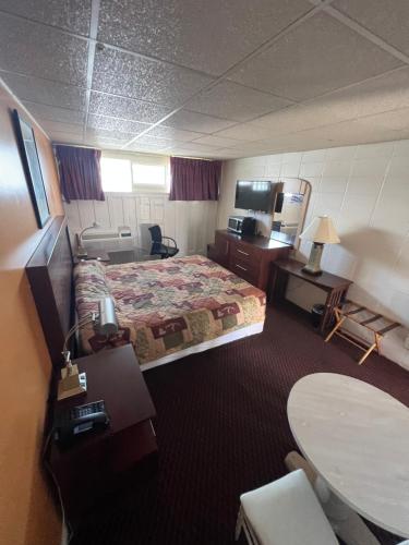 新荷兰Hollander Motel的酒店客房配有一张床铺和一张桌子。