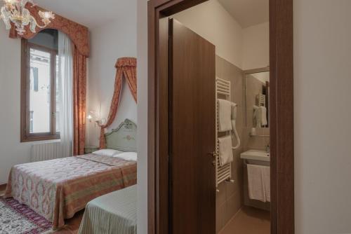 威尼斯Hotel al Sotoportego的一间卧室配有床、水槽和镜子