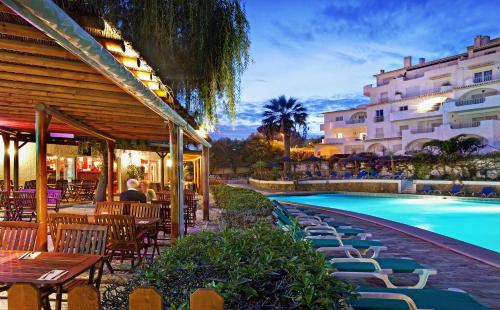 卢斯Luz Ocean Club Apartments的一个带游泳池和桌椅的度假酒店