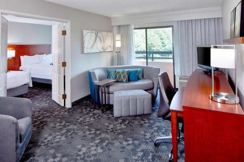 莫里斯维尔Sonesta Select Raleigh Durham Airport Morrisville的酒店客房设有一间带一张床和一张书桌的卧室