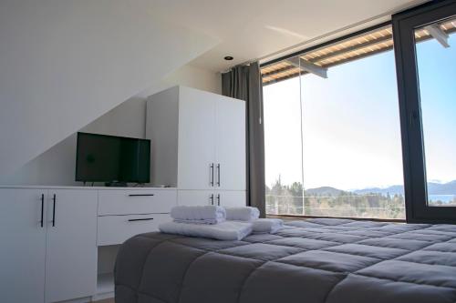 圣卡洛斯-德巴里洛切V&P Apt的一间卧室设有一张大床和一台平面电视。