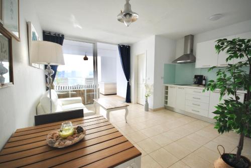 大塔拉哈尔Sailor Lovers - Jacuzzi Fuerteventura的一间厨房和客厅,客厅内配有木桌。
