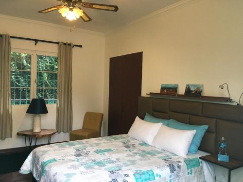 利马La Casona Azul的卧室配有床、椅子和窗户。