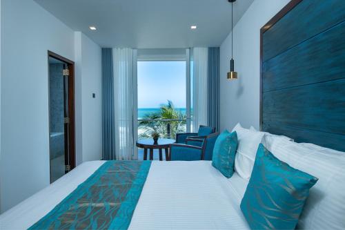 坦加拉Grand Samudra Hotel的一间卧室设有一张床,享有海景