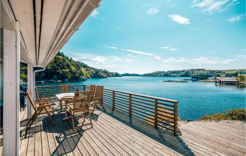 法尔松Gorgeous Home In Farsund With Kitchen的湖景门廊配有桌椅