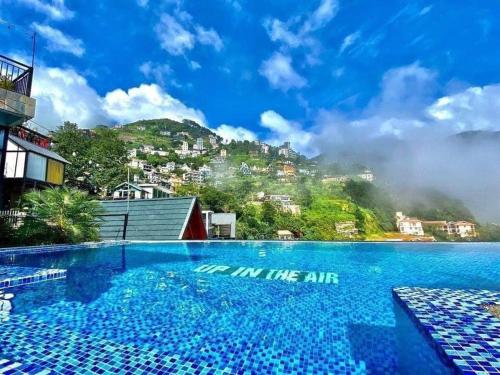 三岛县Nhà Trên Mây - Homstay Tam Đảo的一座蓝色的游泳池,后面是一座山