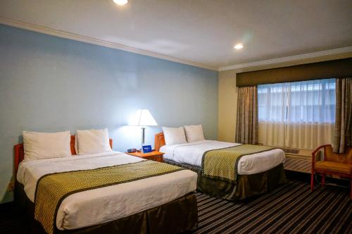 帕罗奥多帕尔马尼酒店的酒店客房设有两张床和窗户。