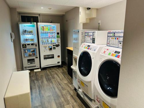 东京银座国际酒店的洗衣房配有2个盥洗盆和2台冰箱