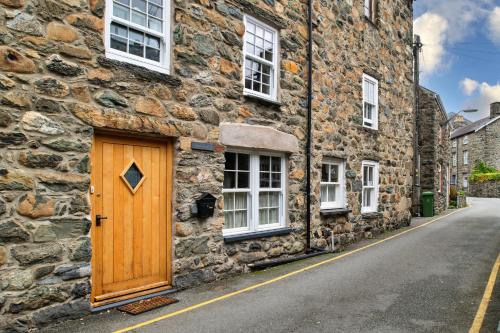 多尔盖罗Finest Retreats - Hope House - Ty Gobaith的石头建筑一侧的木门