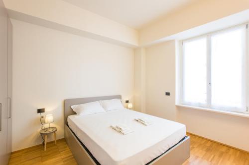 米兰Easylife - Moderno bilocale in zona Porta Romana的白色的卧室设有床和窗户