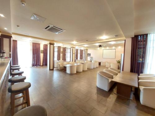 舍基Sheki Olimp Villa的一间大型等候室,配有白色的椅子和桌子