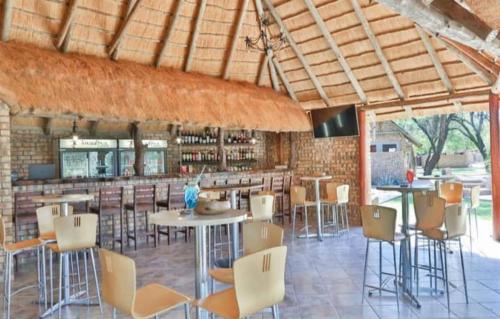 Baines DriftKwadiwa Ranch的一间带桌椅的餐厅和一间酒吧