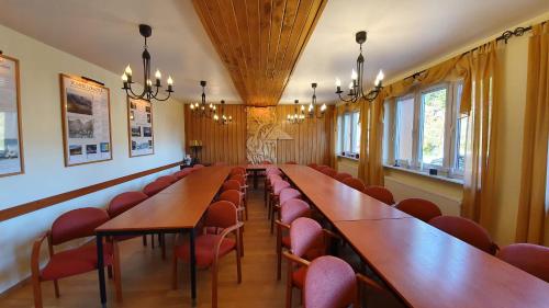 卡尔帕奇Pokoje Gościnne przy kościele Wang.的一间会议室,配有木桌和红色椅子