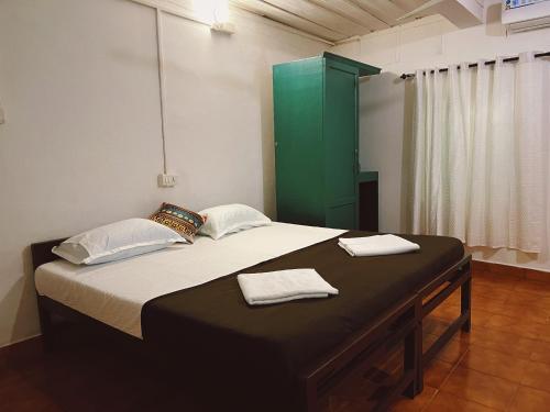 科钦Bunk house Fort Kochi的一间卧室配有一张带绿色橱柜的床