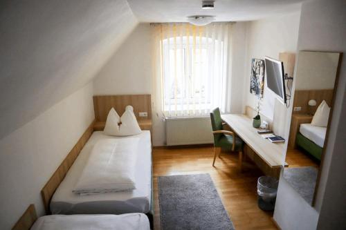 诺德林根Weinstube Sinas Brettl的小房间设有两张床和一张书桌