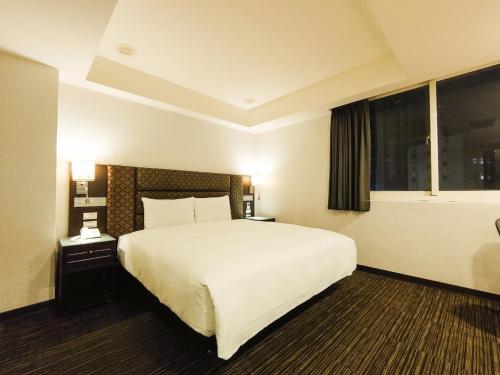 台北Hub Hotel Banqiao Branch的一间设有大床和窗户的酒店客房
