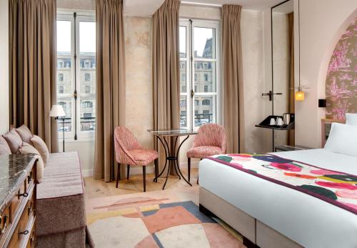 巴黎圣母海岸酒店的酒店客房,配有一张床和一张桌子及椅子