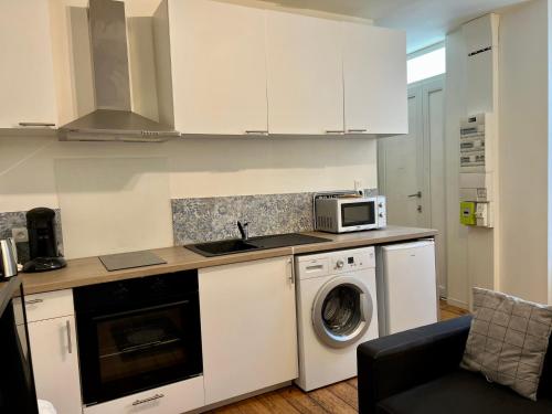 佩里格LE VICTOR HUGO - Wifi - Centre ville - PROPERTY RENTAL NM的厨房配有洗衣机和微波炉。