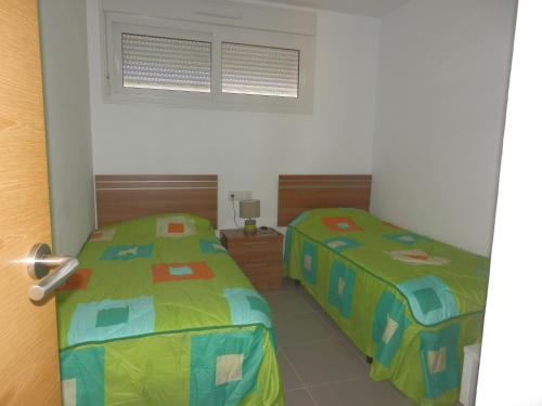 罗尔丹Apartment La Isla Terrazas de la Torre的两张睡床彼此相邻,位于一个房间里
