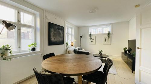 哥本哈根ApartmentInCopenhagen Apartment 1514的一间带木桌和椅子的用餐室