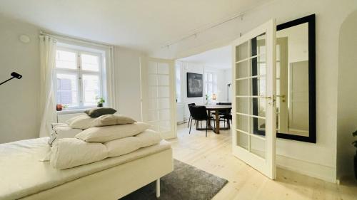 哥本哈根ApartmentInCopenhagen Apartment 1514的一间白色的卧室,配有床和用餐室