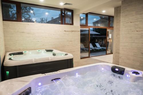 巴尼亚Хотел Сидни的大型客房设有按摩浴缸,