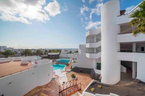 科斯塔特吉塞Apartamentos Lanzarote Paradise Colinas的享有带游泳池的建筑的外部景色