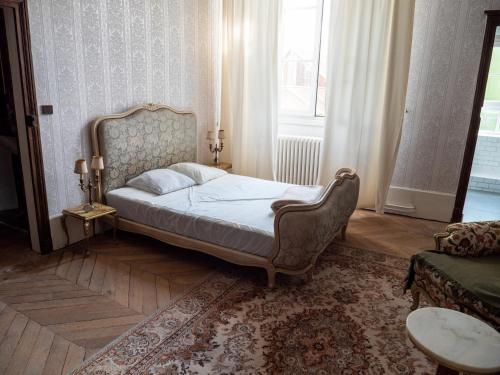 VitteauxGamotel的一间卧室配有一张床、一张沙发和一个窗口
